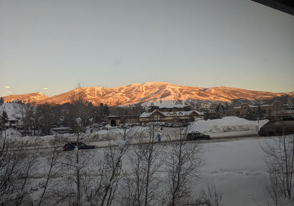 A beautiful mountain view with sun setting with its rays on the peak of the mountain.